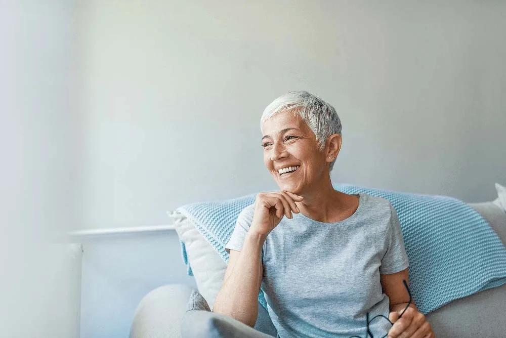 Smiling senior woman relaxing on a couch at home