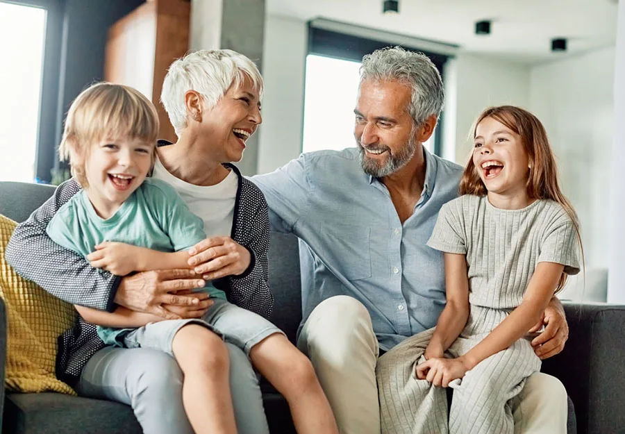 Smiling Family Multiple generations of a family laughing together on a couch